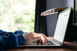 Une personne en train de taper sur un ordinateur portable.